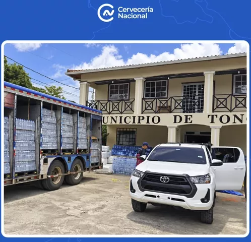 Camión de Cervecería Nacional con agua embotellada frente a un municipio