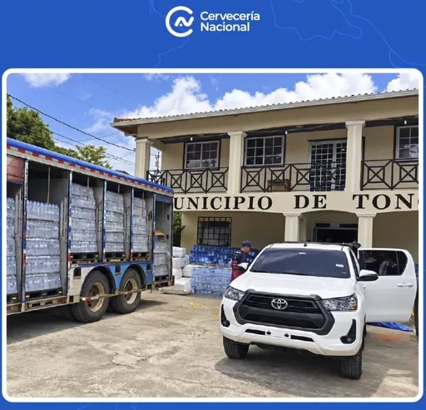 Camión de Cervecería Nacional con agua embotellada frente a un municipio